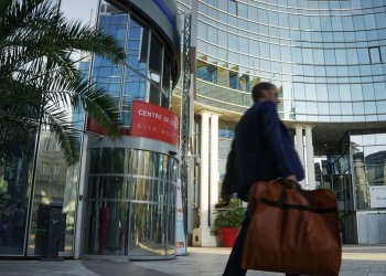 Homme passant devant le Centre de Congrès Cité Mondiale