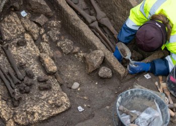Archélogue fouillant une tombe dans un chantier d'archéologie préventive