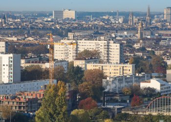 Vue de la rive droite et du quartier la benauge depuis le ciel. On y voit un immeuble blan et un parking au premier plan