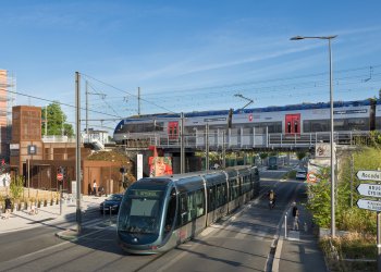 Vue de la gare sainte germaine avec un tramway, un train des vélos et des passants