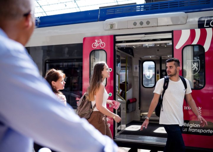 Visuel d'un TER en gare de Bordeaux, au 1er plan à gauche, un homme de dos, en second plan 3 personnes s'apprêtant à monter dans le train