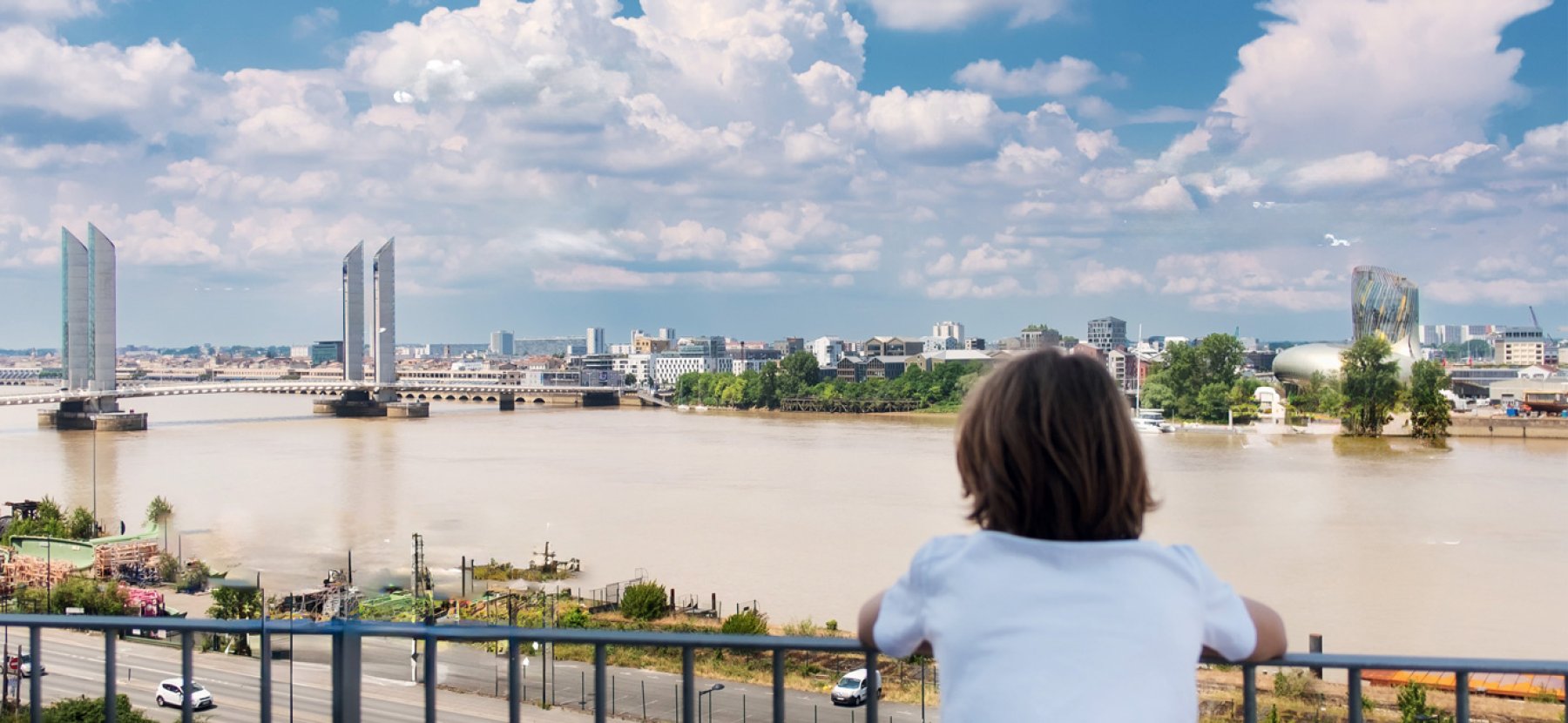 Un enfant regarde la Garonne et le pont Chaban-Delmas