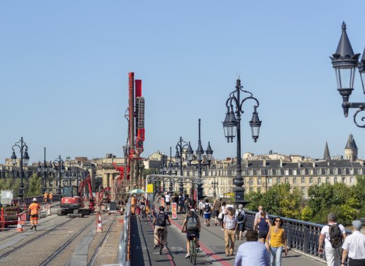 Vue du pont de pierre pendant les travaux avec cyclistes et piétons sans tramway.