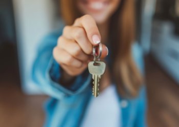 Visuel "Clé en main" d'Adobe Stock : une femme en second plan tient des clés face à elle et à la caméra