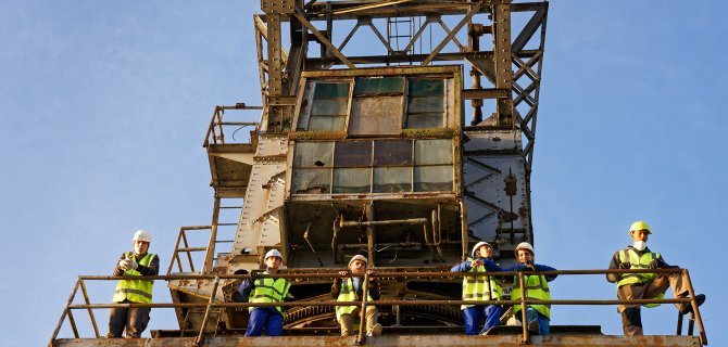 Vue en contre plongée d'ouvriers sur la grue Wellman