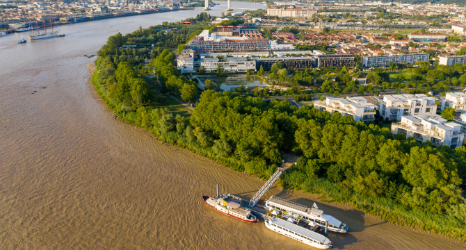 Vue du port de Bordeaux avec un ponton et un bateau sur la garonne près des arbres