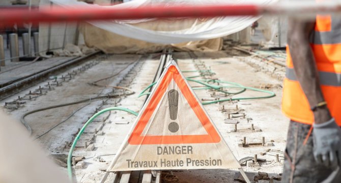 Vue d'une paneau "danger travaux haute tension" sur les rails du tramway