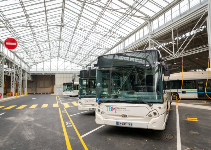 Vue d'un bus dans la Halle Lescure, avec la verrière et des bus en arrière plan