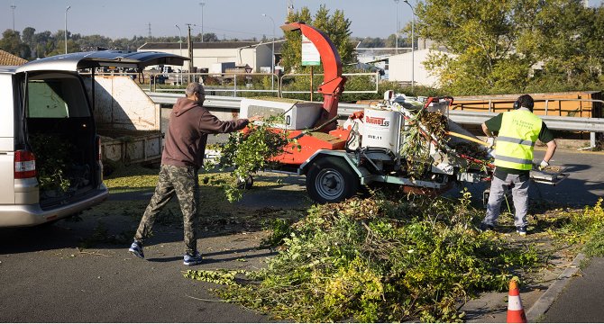 2 hommes en train de broyer des déchets verts